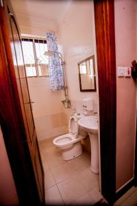 La salle de bains est pourvue de toilettes et d'un lavabo. dans l'établissement B10 Airport Lodge, à Dar es Salaam