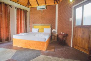 a bedroom with a large bed with a brick wall at Rice Rice Villas in Tissamaharama