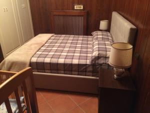 a small bedroom with a bed with a plaid blanket at Maison Il Colle in Rivisondoli