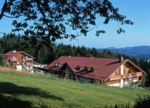 ein großes Haus mit rotem Dach auf einem Hügel in der Unterkunft Apartman Šumava - Bavorský les in Mitterfirmiansreut