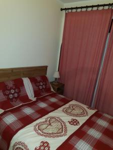 a bedroom with two beds with red and white blankets at Il Nido in Sestriere