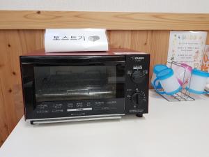 un horno microondas sentado en la parte superior de un mostrador en Midori Guesthouse&Hostel en Tsushima