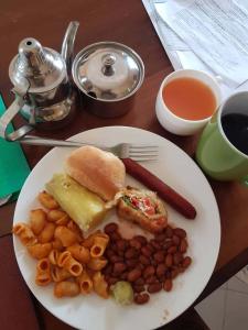 a white plate of food with a sandwich and beans at B10 Airport Lodge in Dar es Salaam