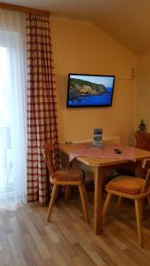 ein Esszimmer mit einem Tisch und Stühlen sowie einem TV in der Unterkunft Haus Gabriele in Bad Mitterndorf