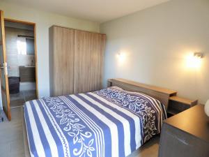 um quarto com uma cama com um cobertor azul e branco em F2 contemporain refait à neuf avec terrasse à 5 minutes de la plage em La Seyne-sur-Mer