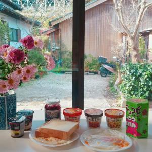a table with a plate of food and a sandwich at Midori Guesthouse&Hostel in Tsushima