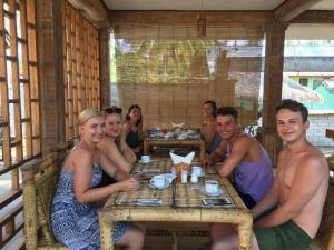 a group of people sitting at a table in a restaurant at Island Beach Bungalow in Gili Trawangan