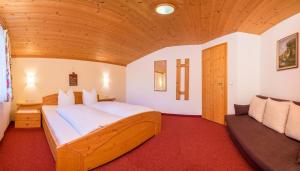 um quarto com uma cama grande e um sofá em Ferienwohnung Mair em Neustift im Stubaital