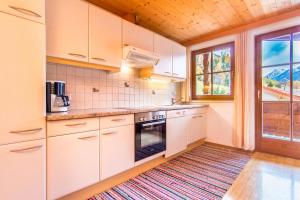 een keuken met witte kasten en een tapijt op de vloer bij Ferienwohnung Mair in Neustift im Stubaital