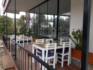 a restaurant with white tables and chairs on a balcony at Liona Hotel & SPA in Gundogan