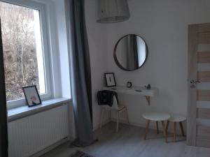 a white room with a mirror and a table and a window at Apartament przy Mickiewicza in Stronie Śląskie