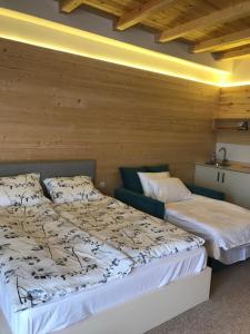 2 Betten in einem Zimmer mit Holzwänden in der Unterkunft New Gudauri Suites in Gudauri