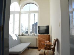 uma sala de estar com uma televisão e uma mesa e janela em Old village train station em Pondrôme