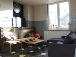 uma sala de estar com um banco e um sofá azul em Old village train station em Pondrôme