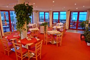 een restaurant met tafels, stoelen en ramen bij Seehotel Weit Meer in Waren