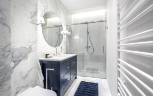 a bathroom with a shower, sink, and mirror at Nowa Motława/Victoriapartments in Gdańsk