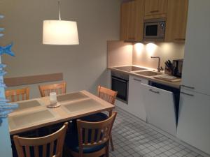 a kitchen with a table and chairs and a kitchen with a christmas tree at Komfortapartment Zingster-Meerblick in Zingst