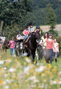 een groep mensen die paardrijden in een veld bij Reiterhof Mühlbauer in Grattersdorf