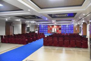 a large room with red chairs and a blue carpet at Hotel Simran Pride, Raipur in Raipur