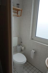 a white toilet sitting in a bathroom next to a window at Stern Hotel in Leipzig