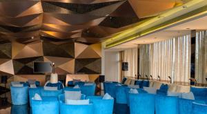 a lobby with blue chairs and a geometric wall at Azaya Beach Resort Goa in Benaulim +37 photos