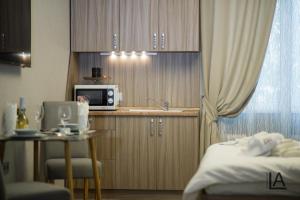Apart hotel Lake Apartments في كييف: غرفة مع مطبخ مع طاولة وميكروويف