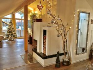 a living room with a christmas tree and a fireplace at Shania Residence in Übersee