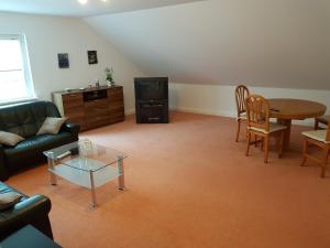 ein Wohnzimmer mit einem Sofa, einem Tisch und einem TV in der Unterkunft Apartments Haupt in Kobern-Gondorf