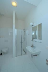 a white bathroom with a shower and a sink at Debo Apartments - contactless check in in Vienna