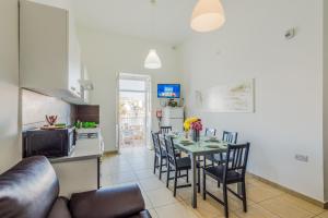 a kitchen and dining room with a table and chairs at Blue Harbour 2 bedroom Seafront Apartments with large terrace with spectacular sea views - by Getawaysmalta in St. Paul's Bay