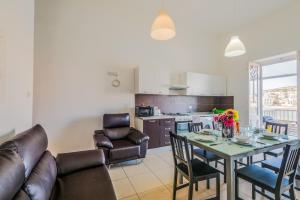 a kitchen and dining room with a table and chairs at Blue Harbour 2 bedroom Seafront Apartments with large terrace with spectacular sea views - by Getawaysmalta in St. Paul's Bay
