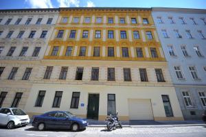 un gran edificio con coches estacionados frente a él en Debo Apartments - contactless check in, en Viena