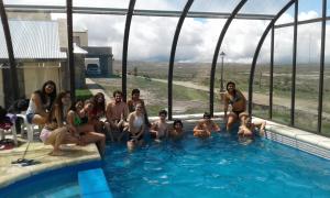 a group of people sitting in a swimming pool at La Posta Hotel y refugio De Montana in Mina Clavero