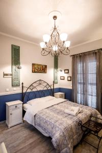 a bedroom with a large bed and a chandelier at Acronafplia Pension B&D in Nafplio