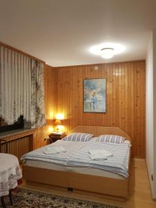 シュチルクにあるEDEN Szczyrkのベッドルーム1室(ウッドパネルのベッド1台付)