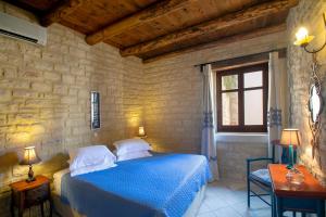 ein Schlafzimmer mit einem blauen Bett und einem Fenster in der Unterkunft Casa Moazzo Suites and Apartments in Rethymno