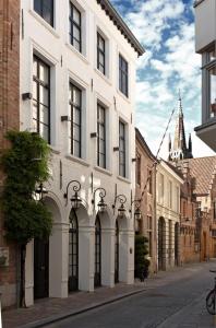 um edifício branco com arcos numa rua da cidade em Hotel De Orangerie by CW Hotel Collection em Bruges