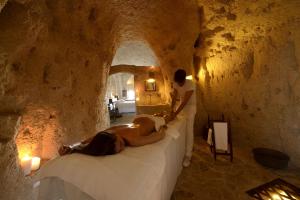 a man laying on a bed in a room at Sextantio Le Grotte Della Civita in Matera