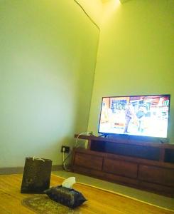 a living room with a flat screen tv on a table at Rumah Nyaman di Kudus in Kudus +3 photos