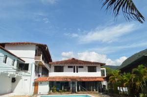 a building with a swimming pool next to a house at Hotel Campestre La Ribera del Fonce in San Gil