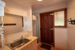 a bathroom with a sink and a wooden door at Stargazers in Pemberton