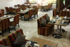 a dining room with tables and chairs and tablesktop at Palm Hotel in Baghdād