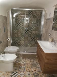 een badkamer met een douche, 2 wastafels en een toilet bij Casa di Giò - Duomo in Napels