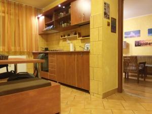 een keuken met houten kasten en een tafel in een kamer bij Apartament Sonia ARHB 3 camere in Boekarest