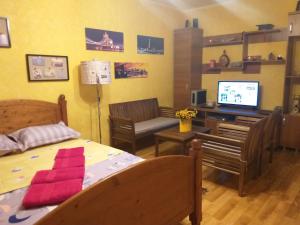 Habitación con cama y escritorio con TV. en Apartament Sonia ARHB 3 camere, en Bucarest
