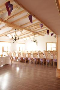 un salón de banquetes con mesas y sillas blancas en Daglezja en Przyborów