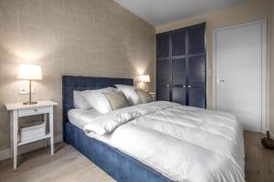 a bedroom with a large bed with a blue headboard at Nowa Motława/Victoriapartments in Gdańsk