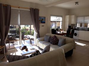 a living room with a couch and a table at Sirena Sunrise Prestige apartments in Paphos