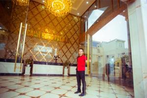 Golden Palace Hotel في هاي فونج: رجل واقف في بهو مبنى
