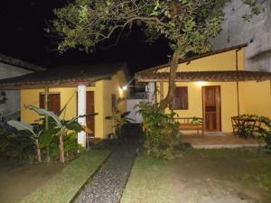 uma casa à noite com uma mesa e uma árvore em Livina Hostel em Paraty